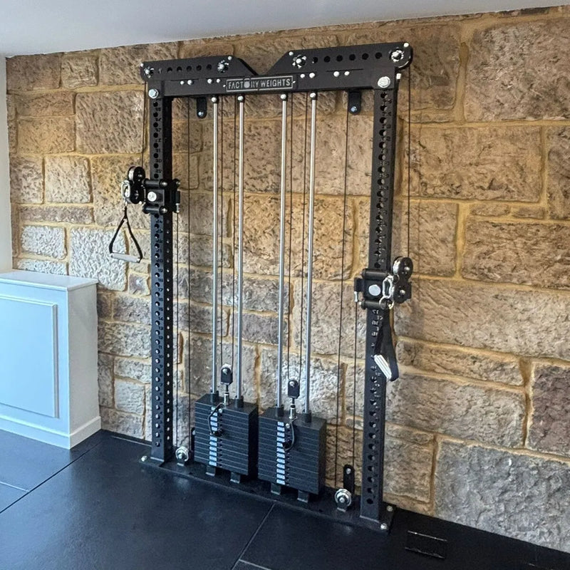 A black and silver cable machine with weight stacks, set against a rustic stone wall background.